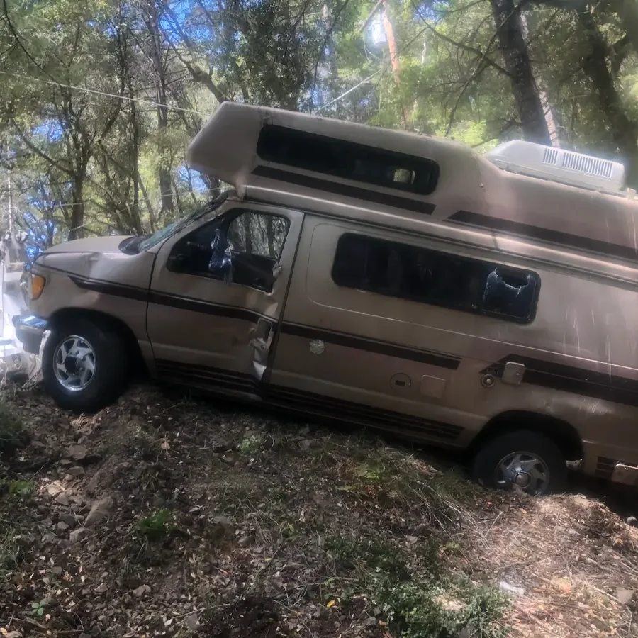 A van is parked on the side of a hill.