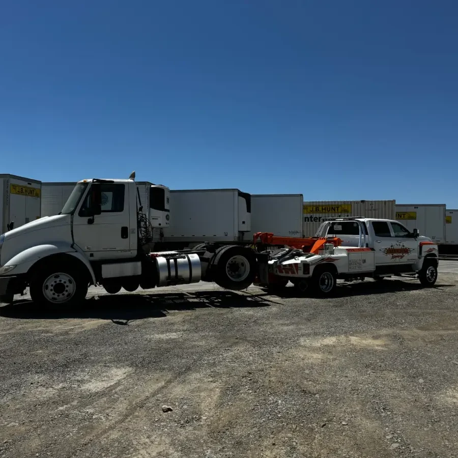 A truck and trailer are parked in the parking lot.