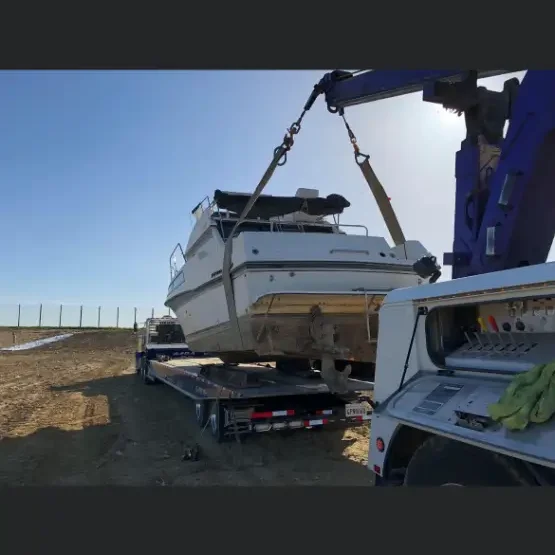 A boat being loaded onto the back of a truck.